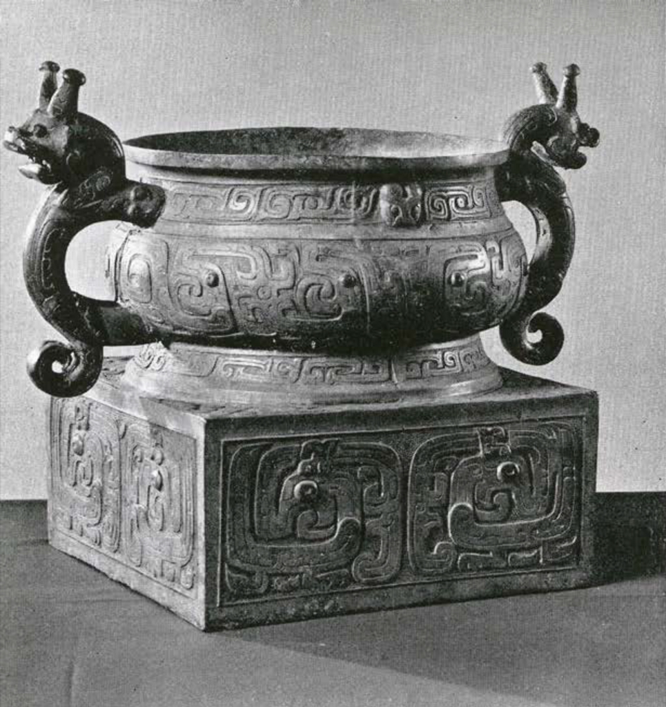Bronze vessel on a square base with two handles in the shape of animals