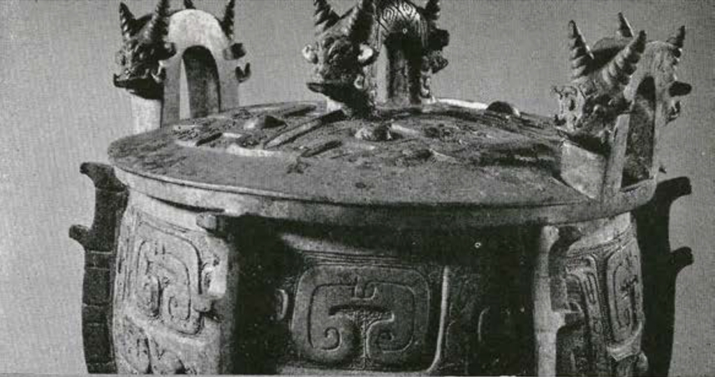 Top and lid of a bronze vessel showing three handles in decorated with horned animals
