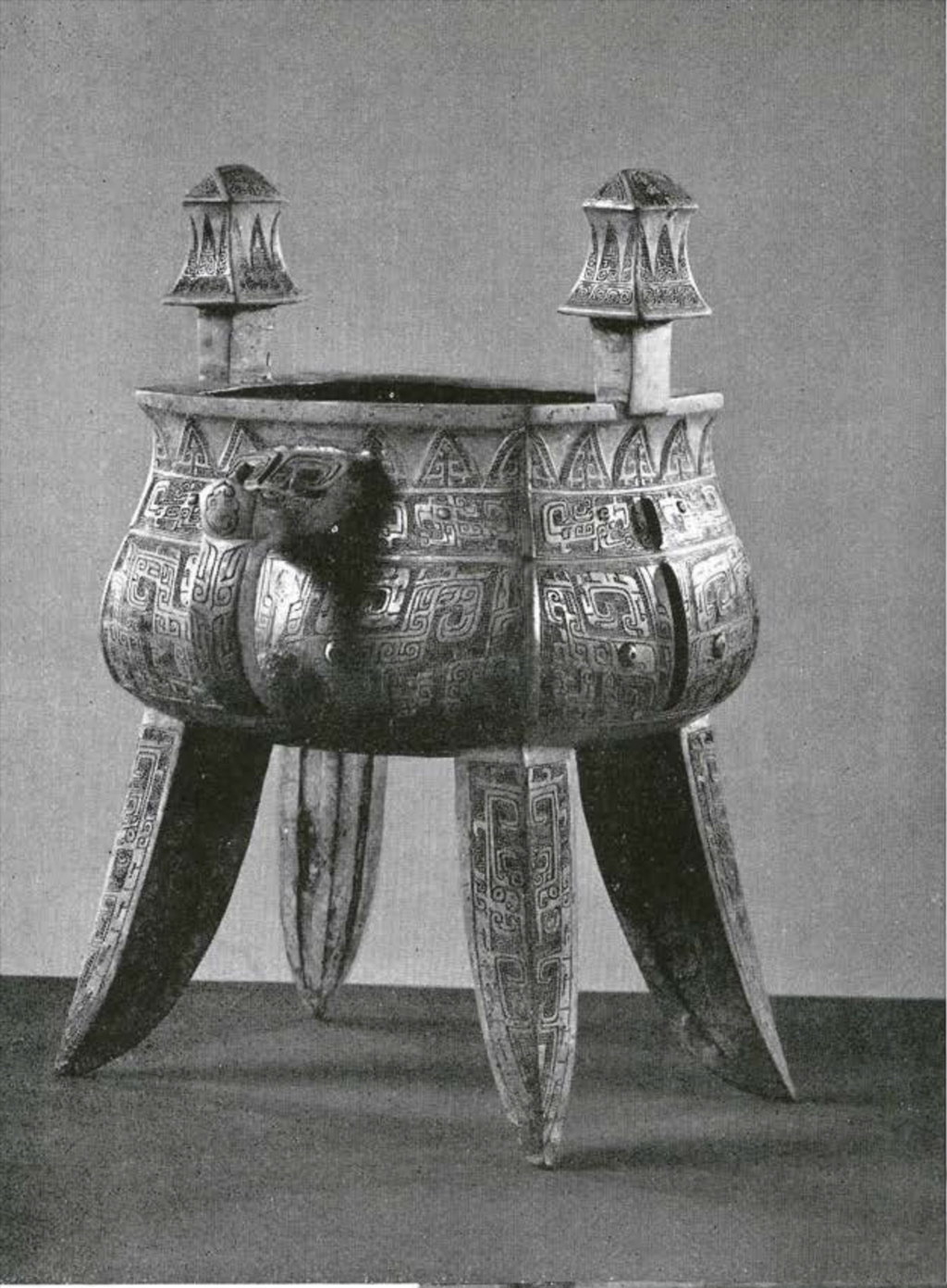 Four legged bronze vessel with two handles in the shape of towers or mushrooms