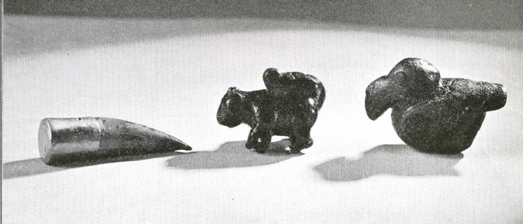 A gold capped tooth, a figurine of a squirrel, and a figurine of a seated bird