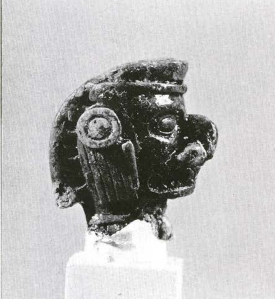 Profile view of a bone piece carved into the shape of a human head
