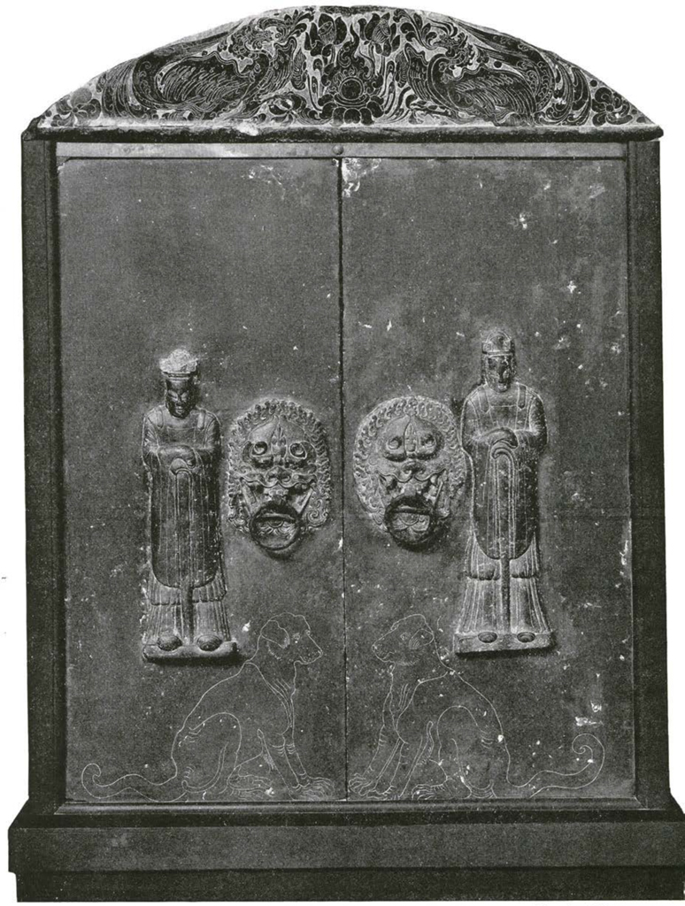 Doors with standing guardians in high relief, dressed in simple robes, to sitting dogs etched beneath them, door handles are in the mouths of beasts, and phoenix lintel decorates the top