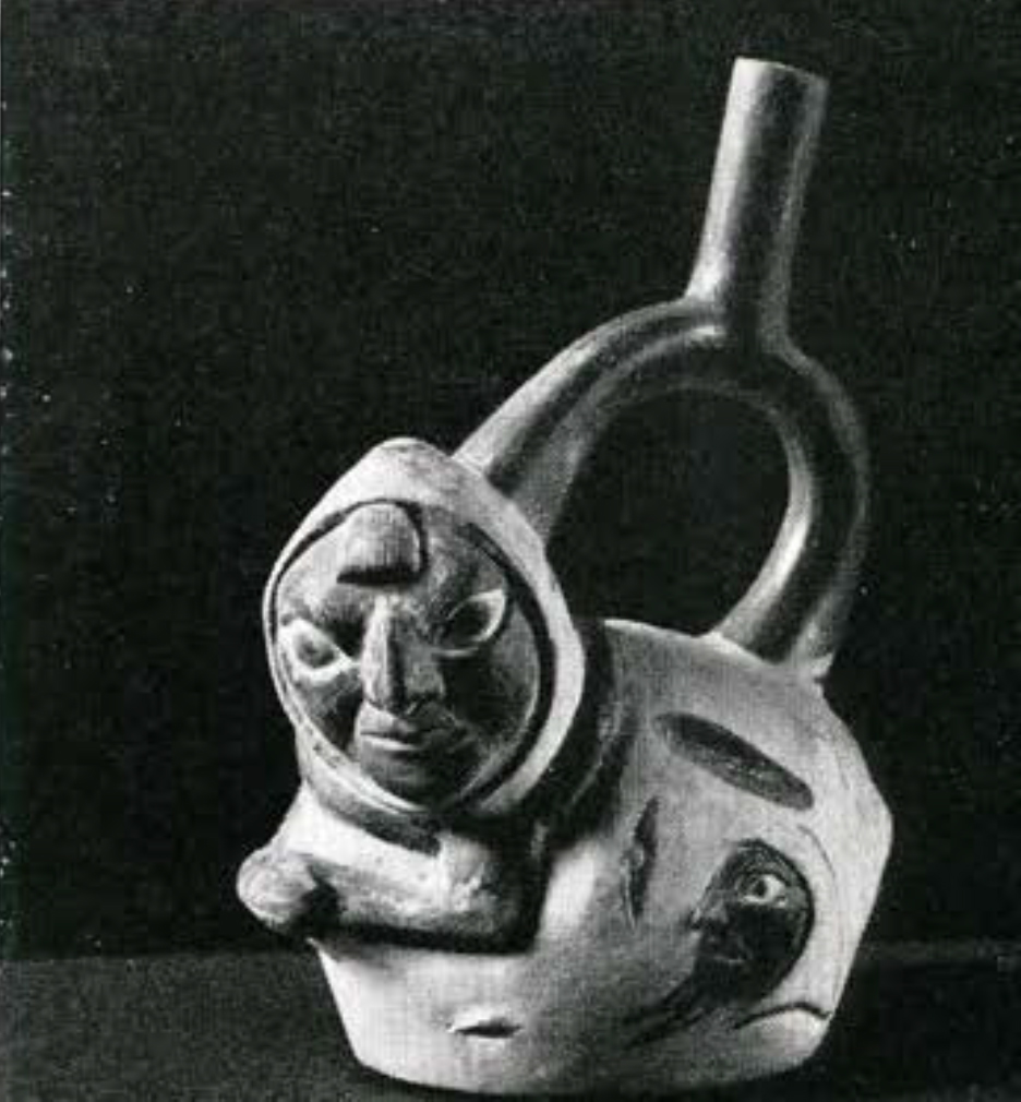 Stirrup spouted effigy vessel in the shape of a potato with arms and faces face sprouting