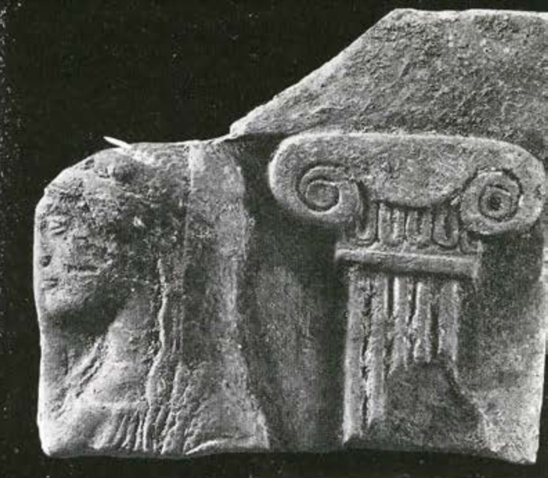 Fragment of a plaque showing the top of a column and a woman's head