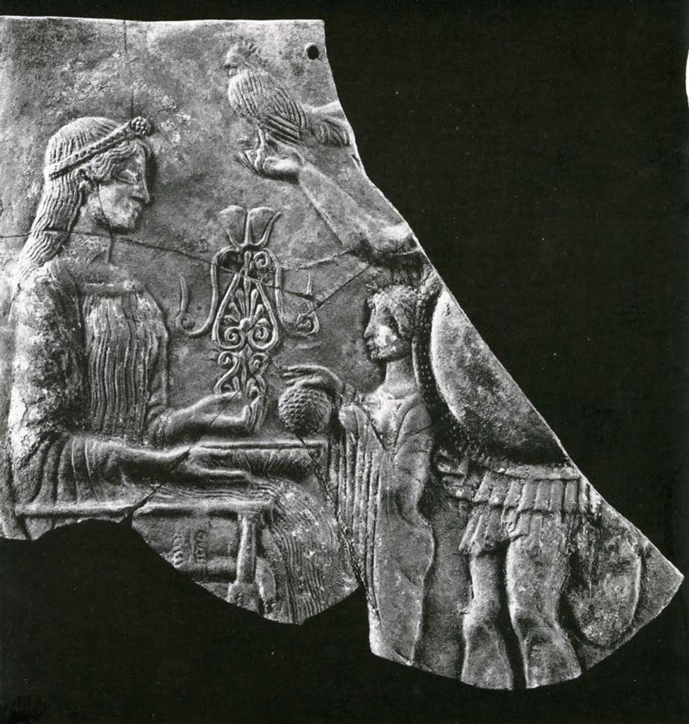Several fragments of a plaque pieced together to show a woman seated on a throne receiving a gift from a smaller woman before her