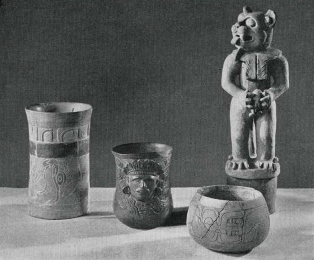 Three carved jars, two cylindrical and one spherical, and a lid or stopper in the shape of a standing jaguar holding a heart