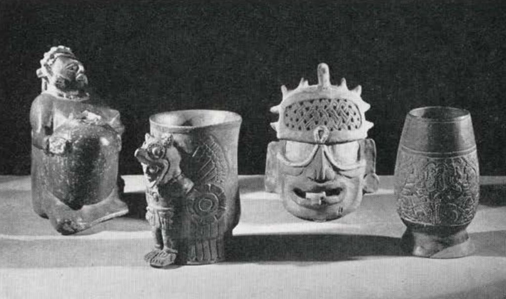 An assortment of vessels and cups in carved into different shapes such as a head, a seated person, and a warrior