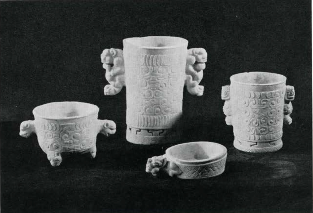 Three marble vases with rectangular glyphs and one marble bowl with carved woven pattern and animal head handle