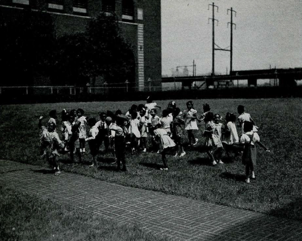 A group of school children dancing in the grass