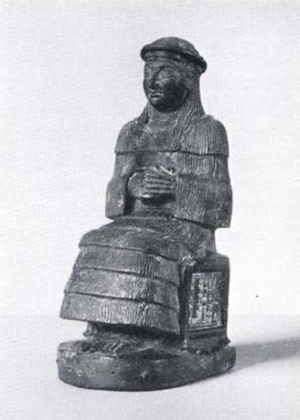 Statuette of a seated lady wearing a flounced garment and with her hands clasped together at her midriff, the panels of her chair are covered with an inscription in cuneiform.