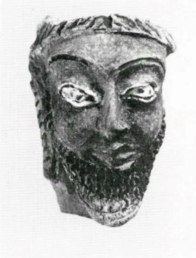 A painted terra cotta head of a man with a bear and headpiece, seen from the front.
