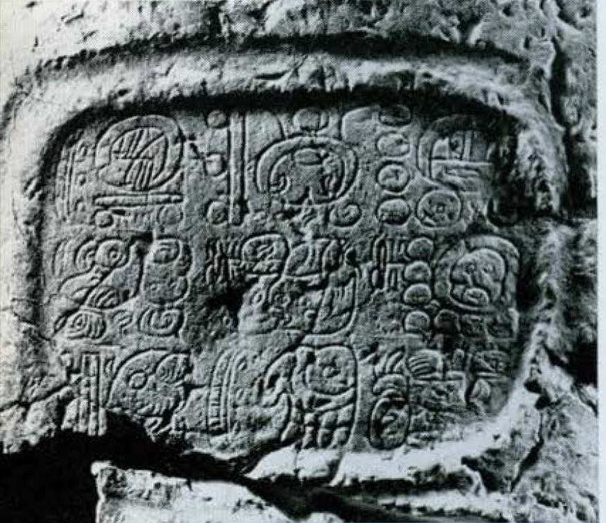 Close up of glyphs carved into an inset oval at the base of a side of Stela 6.