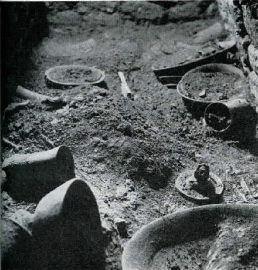 Partially excavated pottery in the ground.