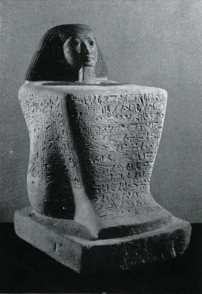Block statue of the overseer of priests, Sitepehu, the form of his body is only faintly perceptible beneath his long robe that completely covers his body and feet, which is in turn covered in inscriptions.