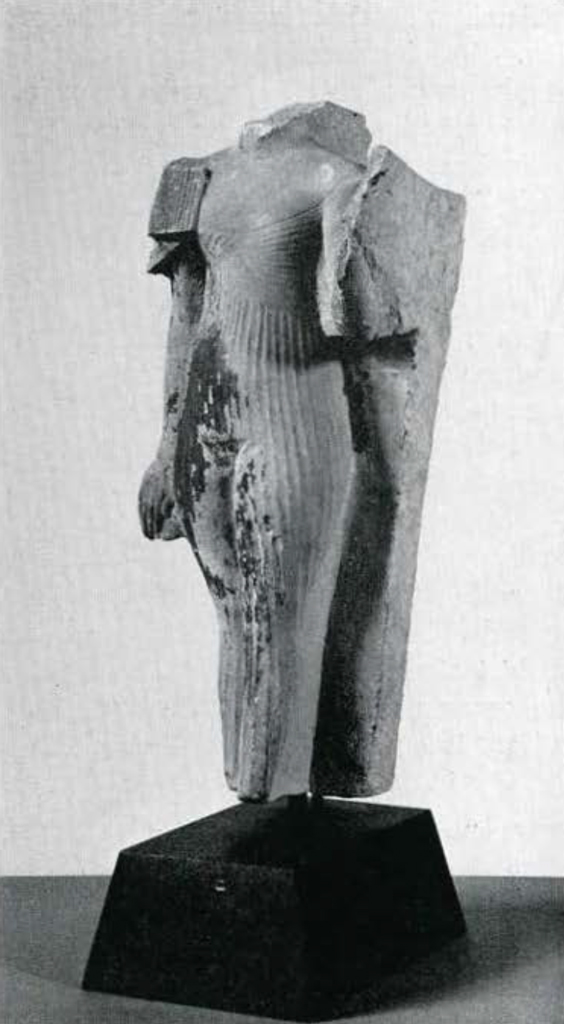 Headless statuette of a princess, probably a daughter of King Akhenaten, wearing a thin, pleated dress with one short sleeve around her upper right arm which hangs straight at her side.