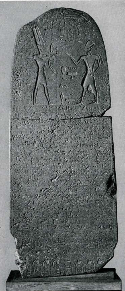 Stela with rounded top, covered in inscriptions.