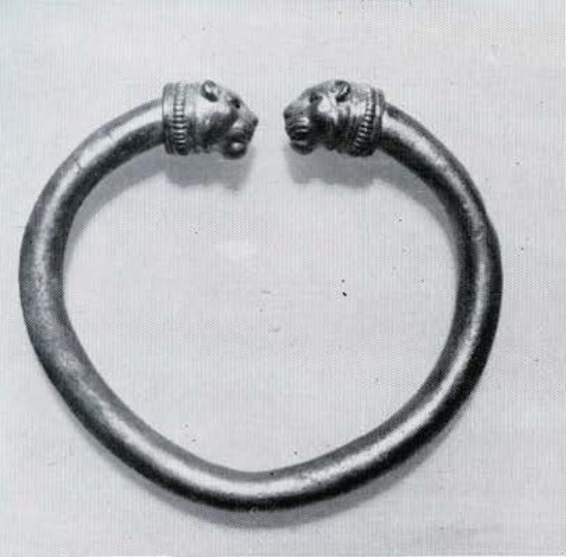 Bracelet is a hollow tube bent to an oval, and ending in lion's heads which were hammered over a form and decorated with grooving, incision and punching.