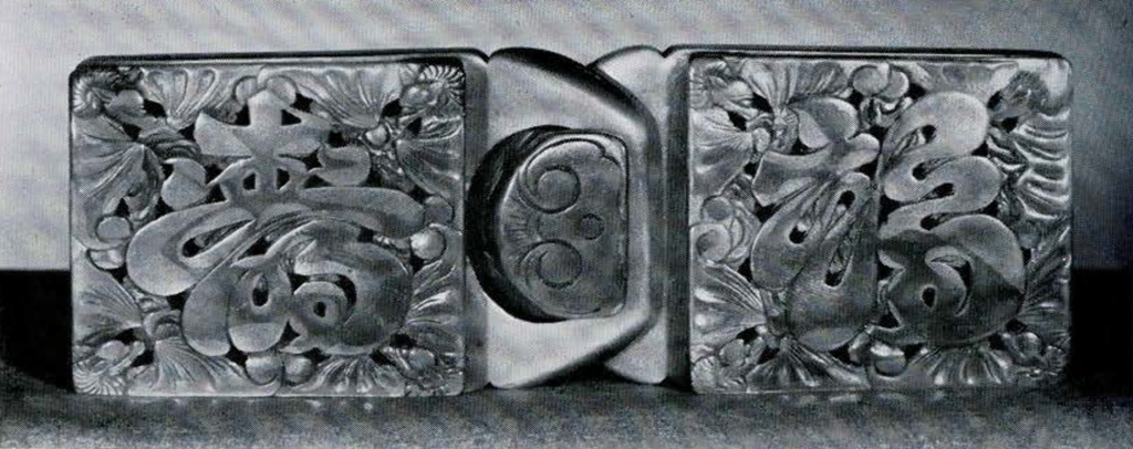 Two piece square buckle with characters carved into it.