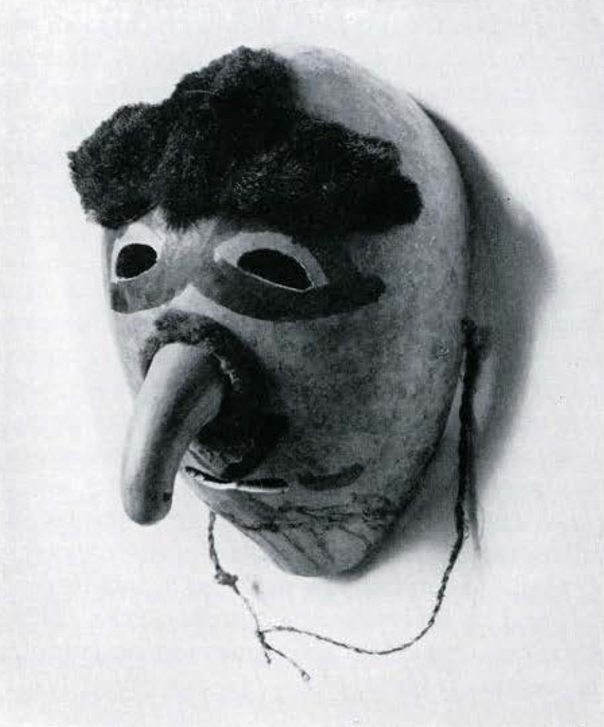 A mask carved from a gourd, the stem of which forms the nose, three tufts of hair on the forehead and painted lines around the eyes, nose, and mouth, and a painted beard.