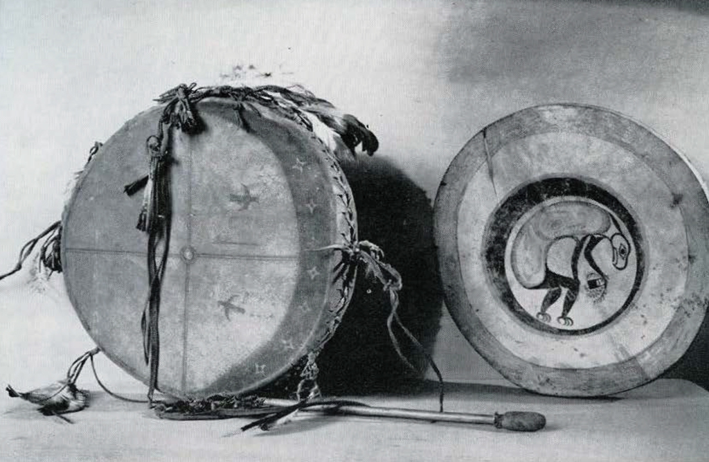 Two round skin drums, and a drumstick.