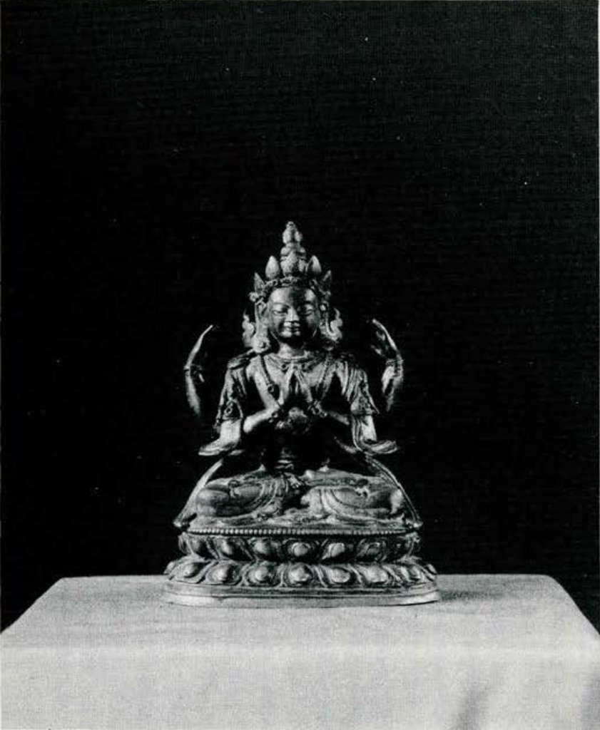 A statue of a seated buddha with hands together praying, wearing an elaborate crown.