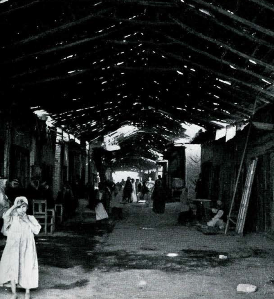 Inside the suq, people and furniture lining the walls.