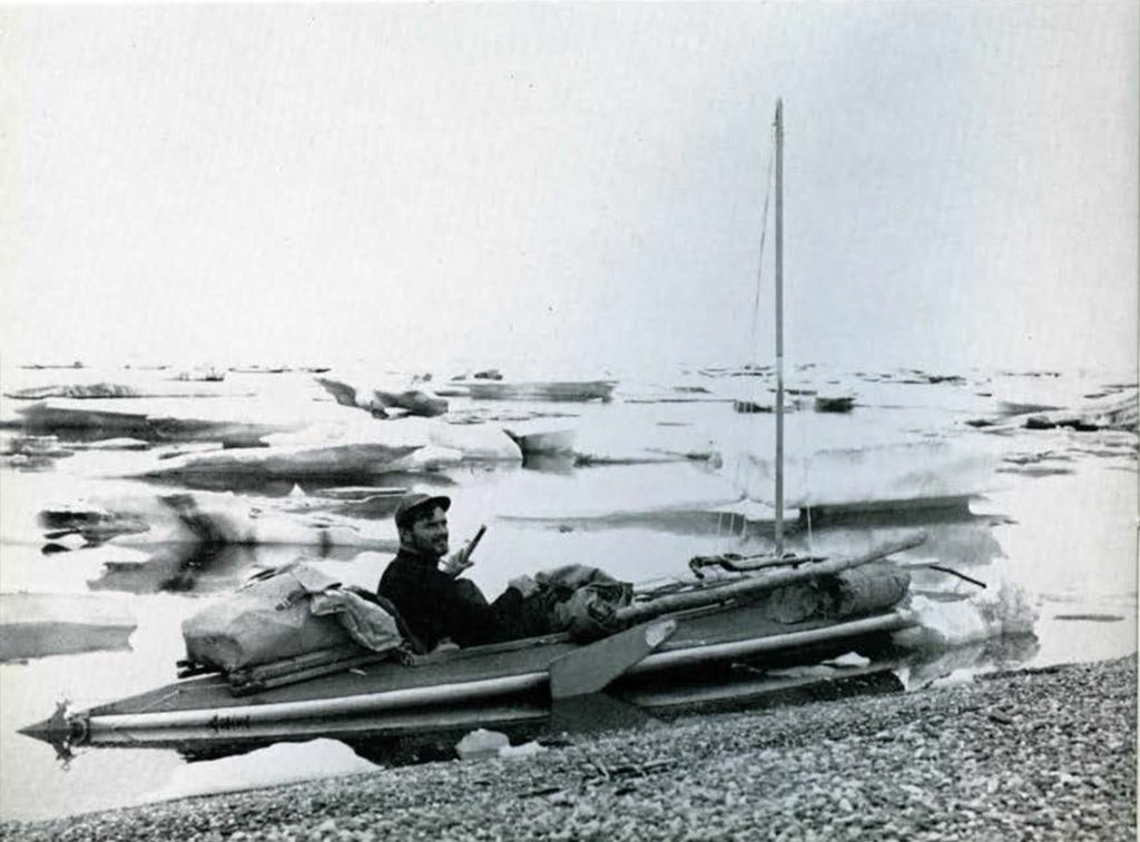 A man in a small boat, ice floes around him.