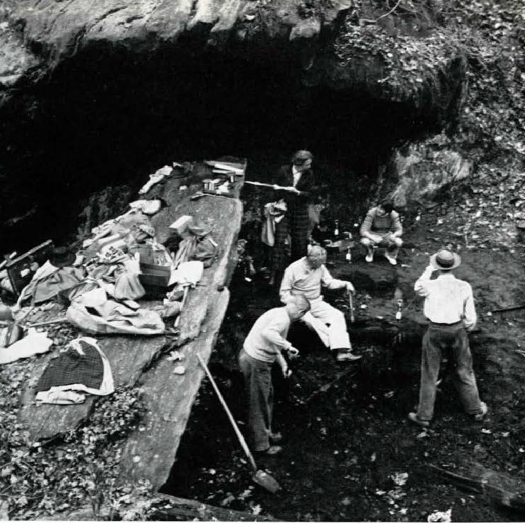 A group of people excavting a rock shelter.