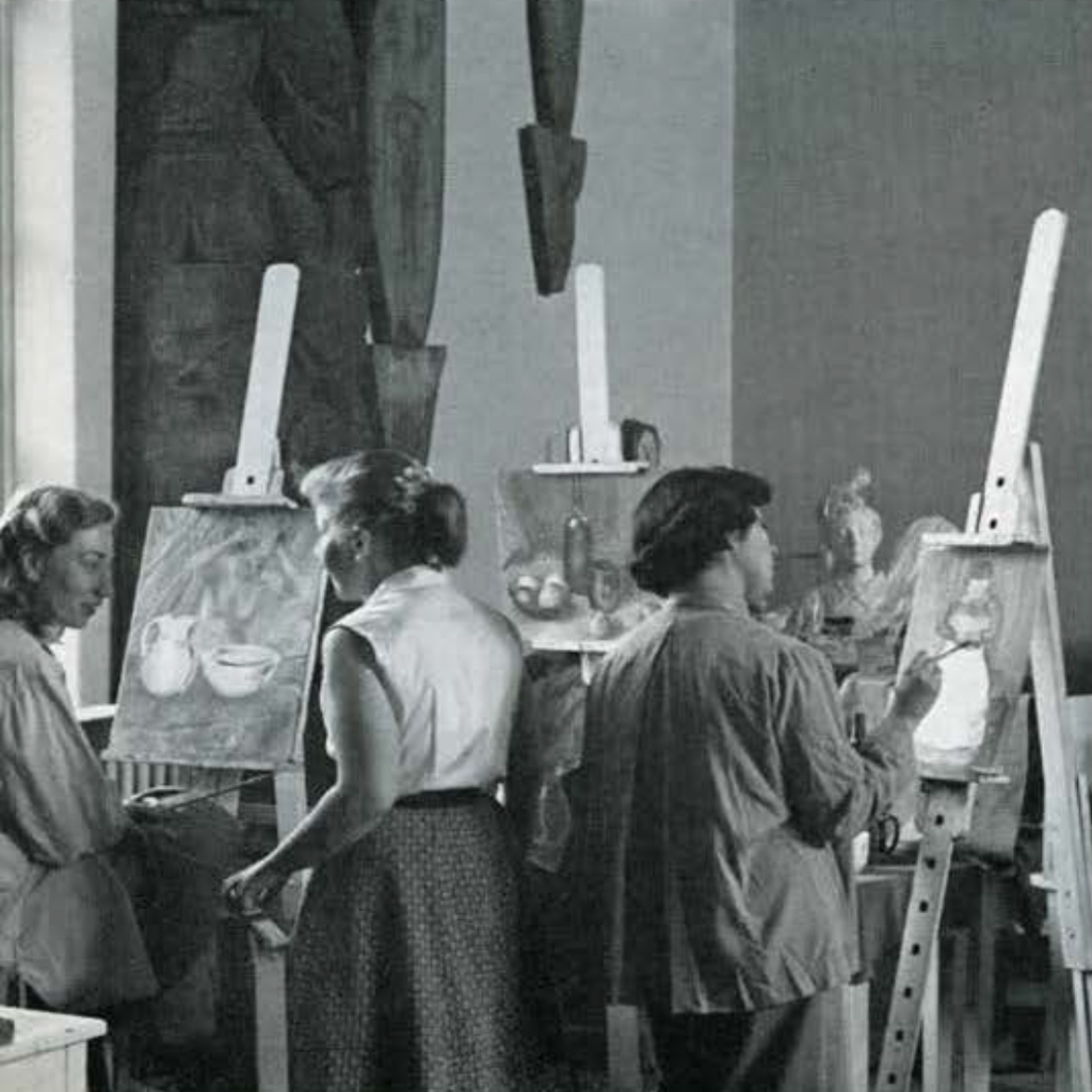 A group of young women with easels set up in the galleries, painting objects.