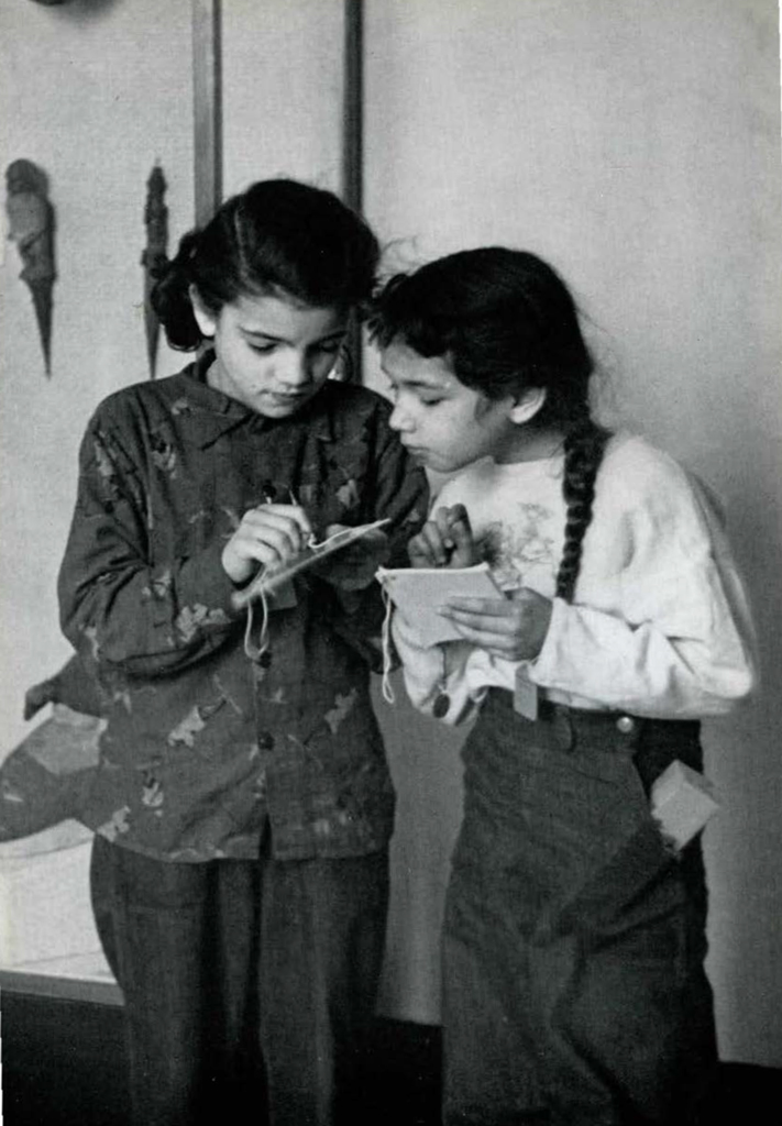 Two young girls taking notes in the galleries.