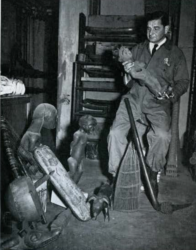A man in collections storage exmaining a small bust.