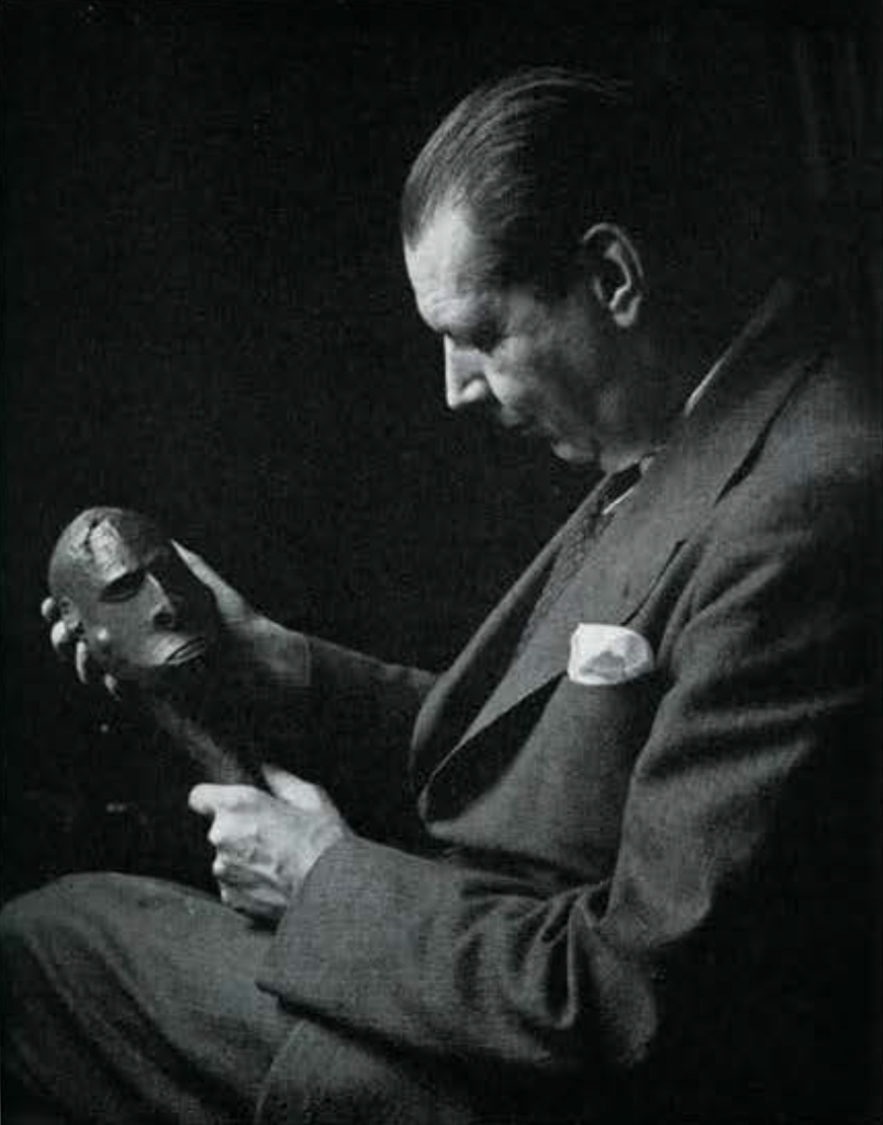 A man holding a wooden head.