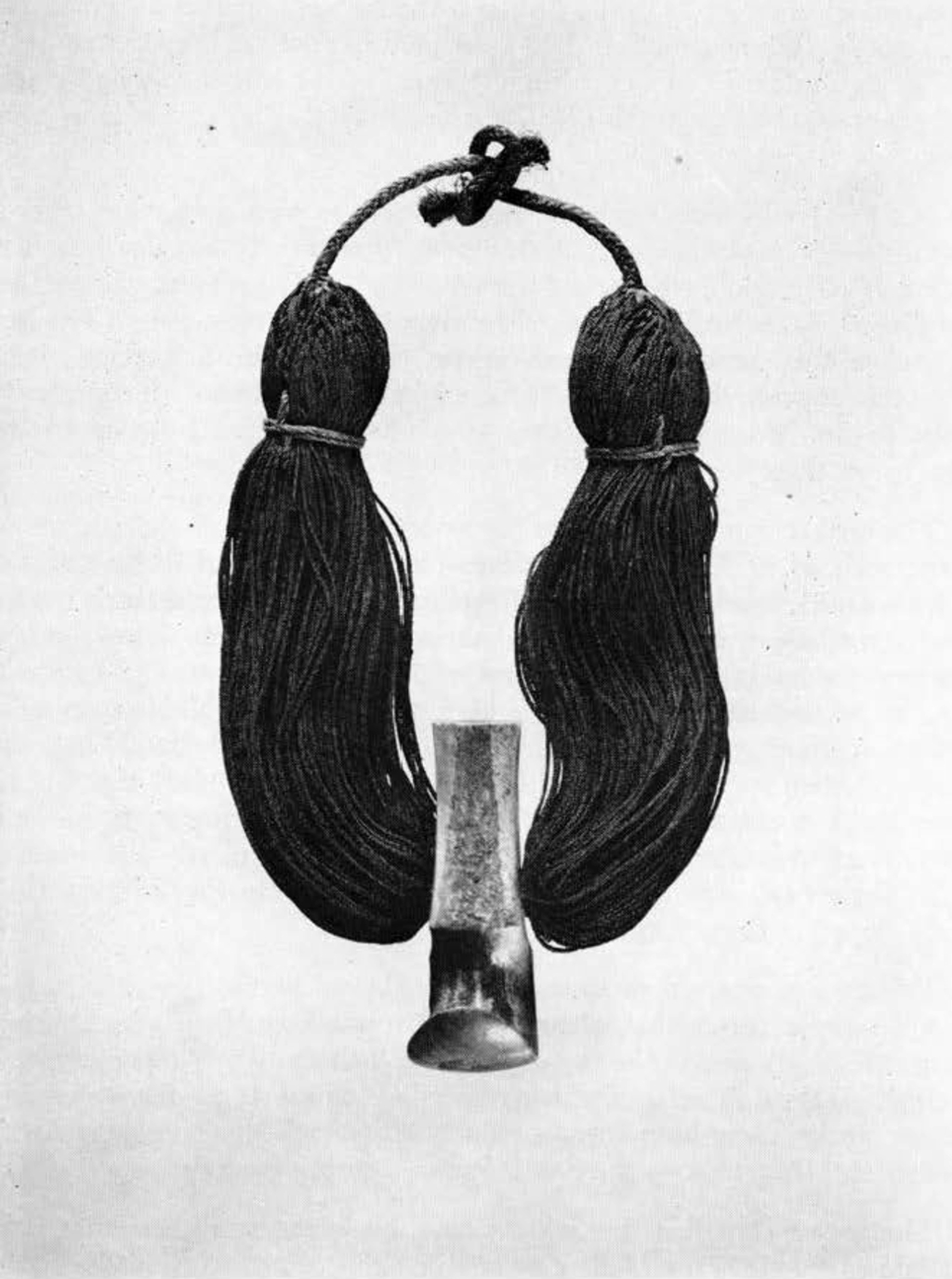 A necklace made of small braids of hair, with a large hook in the middle.