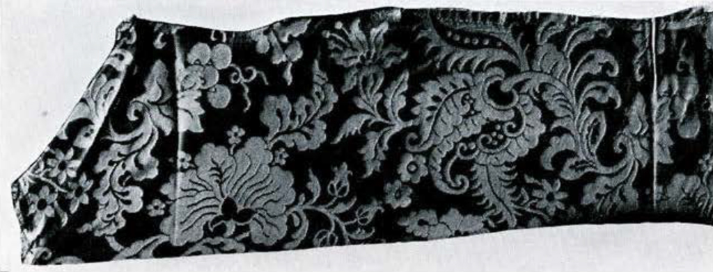 A piece of damask cloth with floral design.
