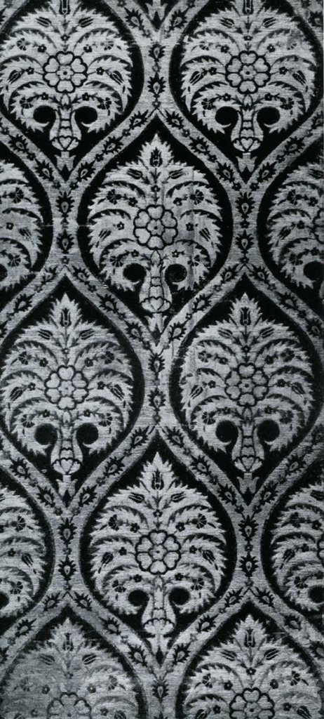 Cut velvet textile with serpentine pattern enclosing a floral motif.