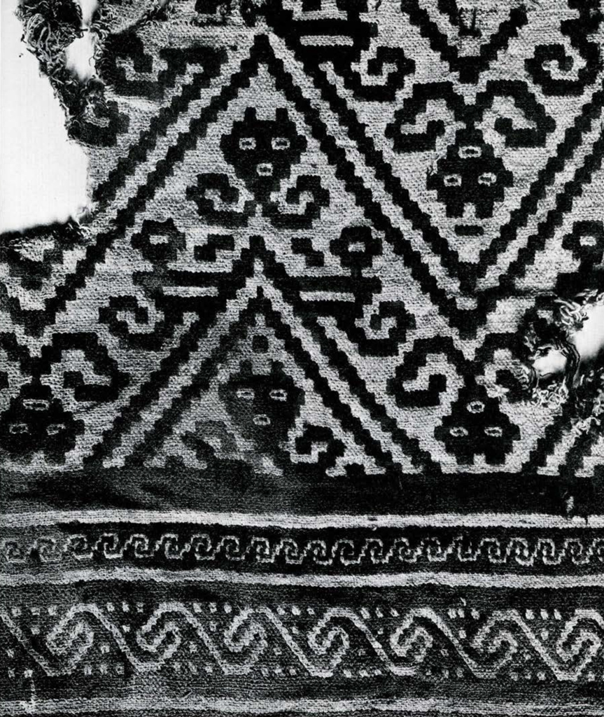 Textile fragment with zig zag design and stylized cat faces.