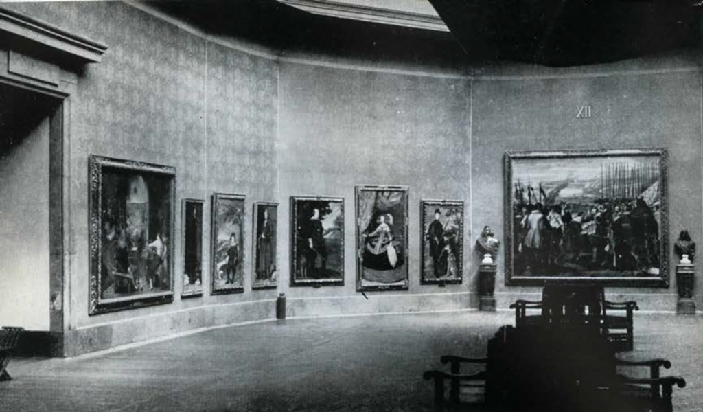 View of a round gallery with large paintings hung on the walls.
