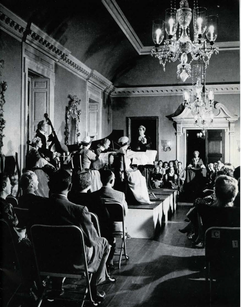A crowd seated on folding chairs, watching a concert.