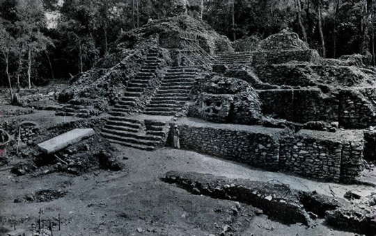 View of a stepped pyramid with a stairway in the middle being excavated.