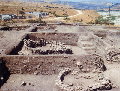 Excavations at Hallan Cemi showing two large huts (center and lower right) and a smaller hut with a flagstone floor. The hut on the right has been cross-sectioned for architectural details.