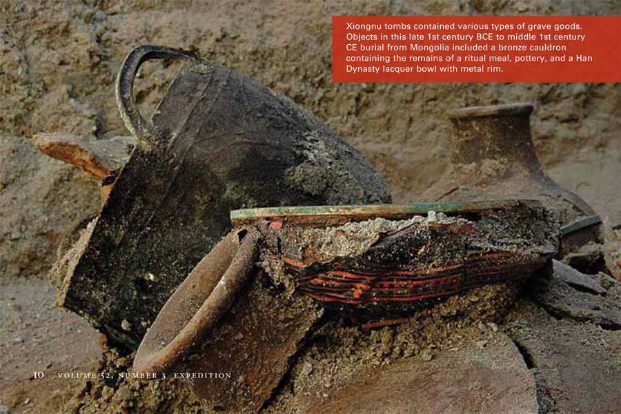 Partial buried objects at a burial, including a cauldron and pots.