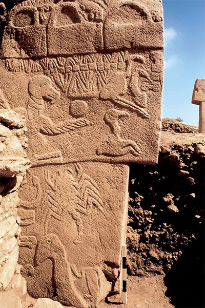 A stone pillar with a variety of animals carved into it, including b=a vulture and a scorpion.