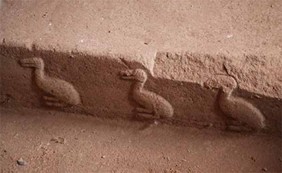 A relief of three ducks in a line.