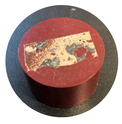 A piece of corroded metal in epoxy