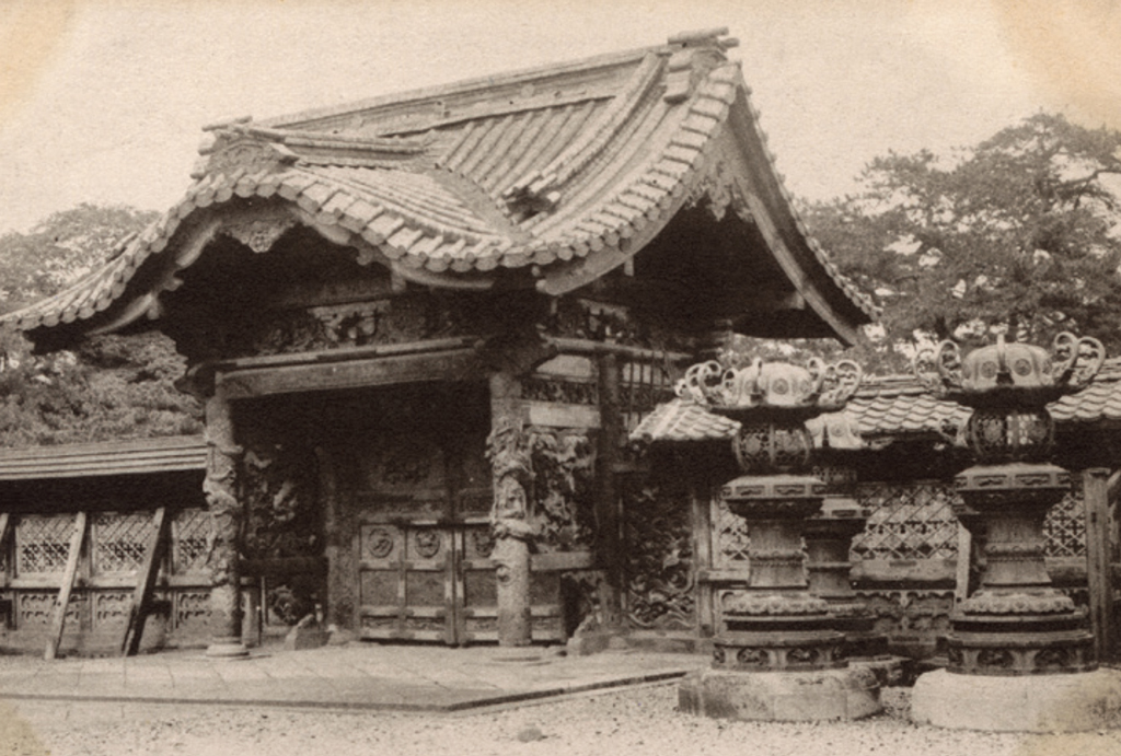 Gate of a mausoleum with many bronze lanterns outside it