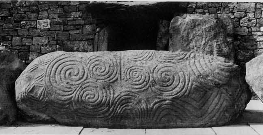 A massive stone with whorls carved into it.