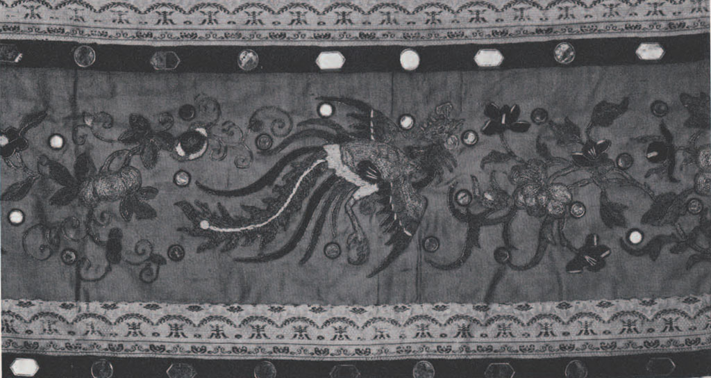 An embroidered cloth with a flying phoenix in the middle surrounded by flowers.