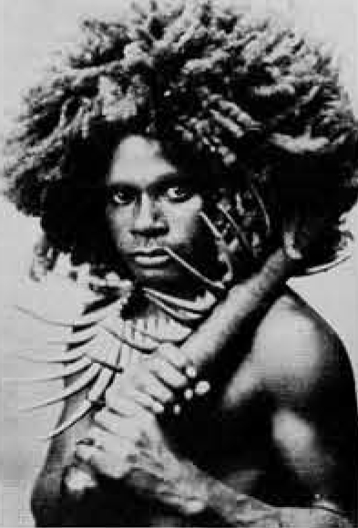Portrait of a Fiji man wearing a necklace, holding implement.
