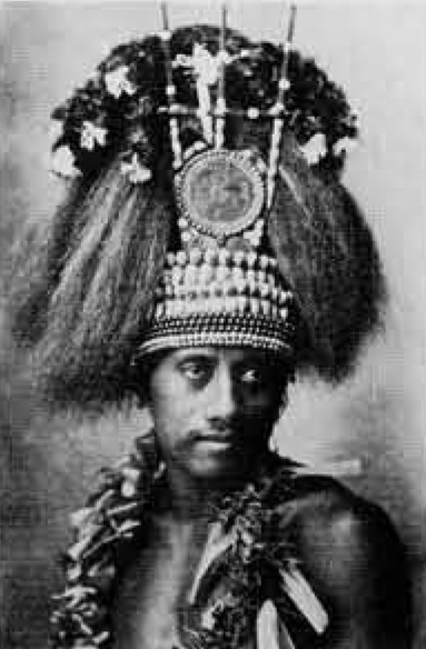 Portrait of a Samoan man wearing a tall headdress and several necklaces.