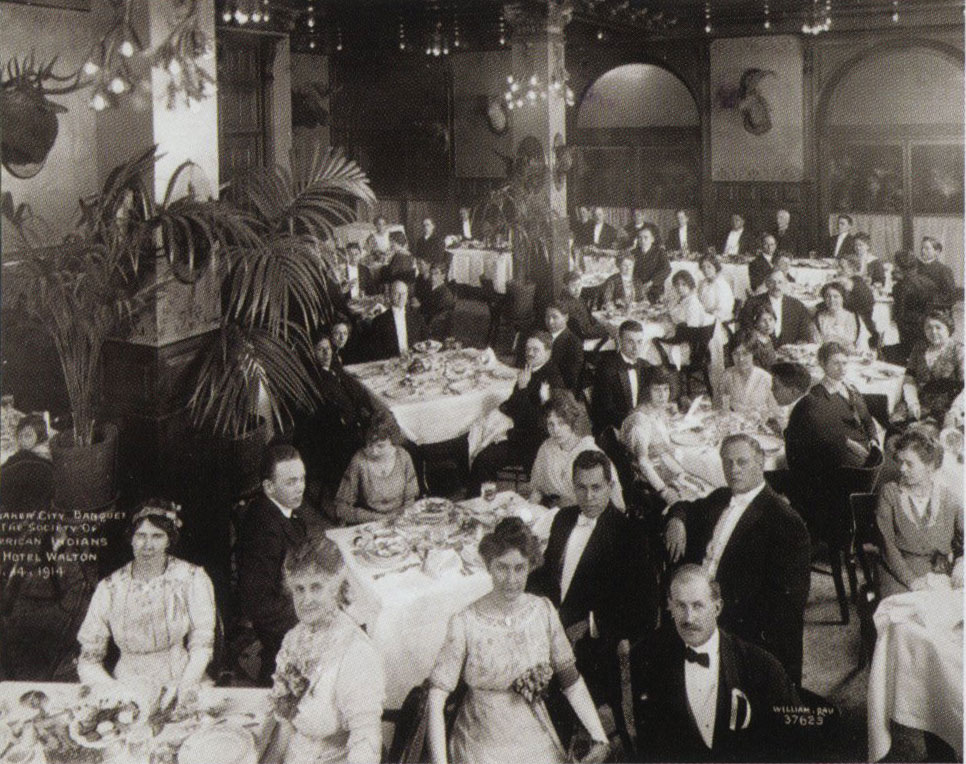 A banquet hall filled with well dressed guests.